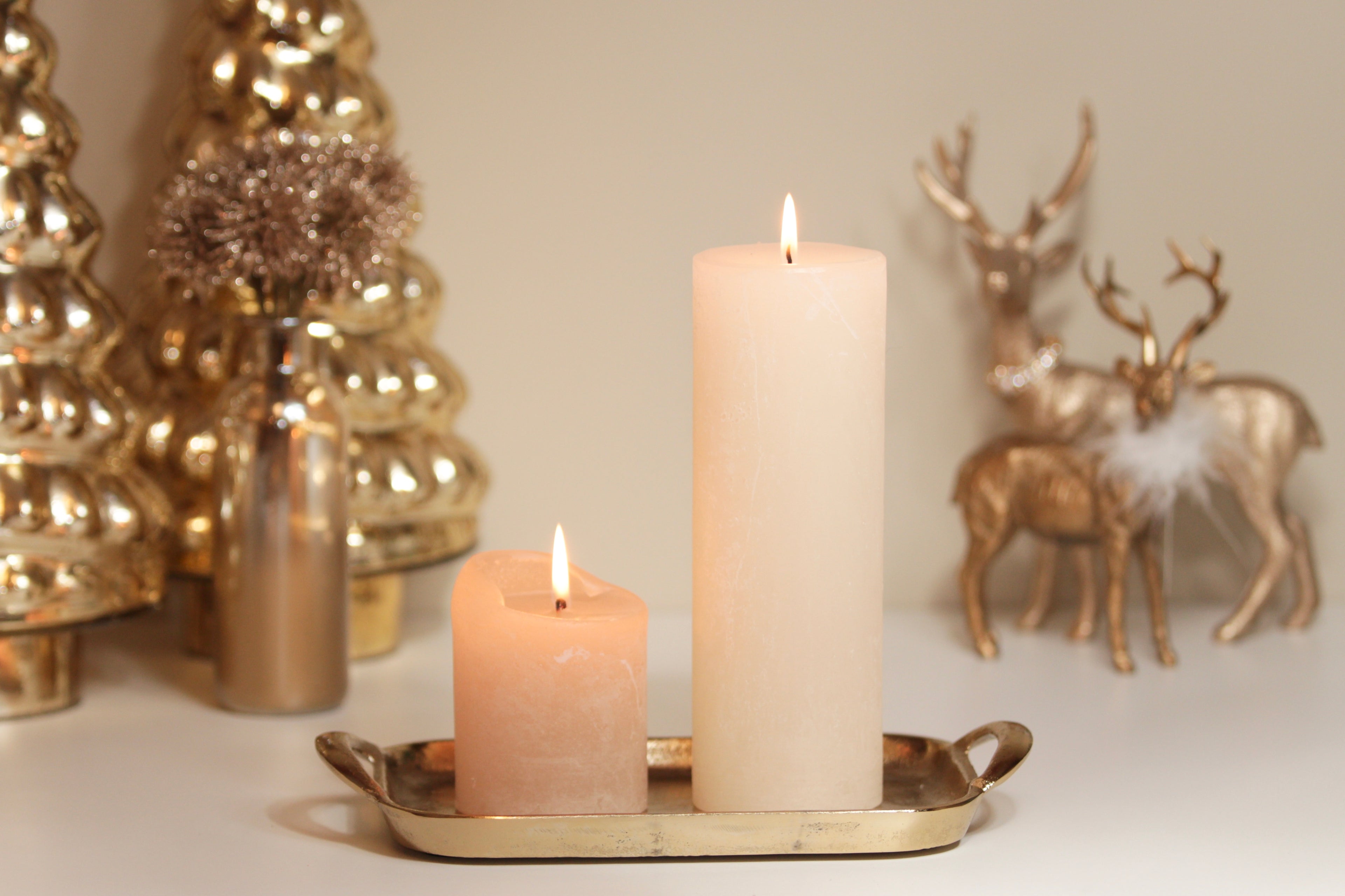 Gemütliche Weihnachtsstimmung mit Kerzen auf goldenem Tablett und edler Dekoration