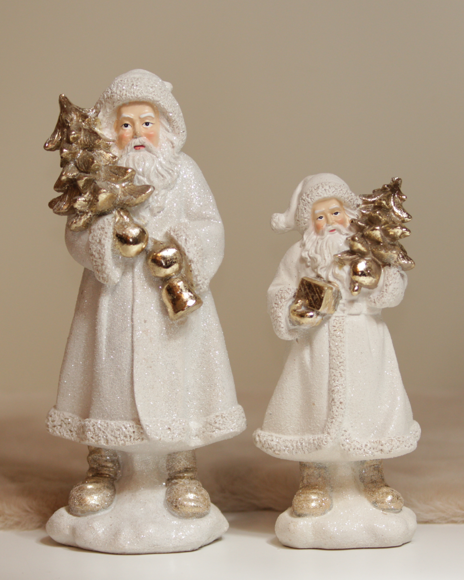Zwei glitzernde Nikolausfiguren in klein und groß.