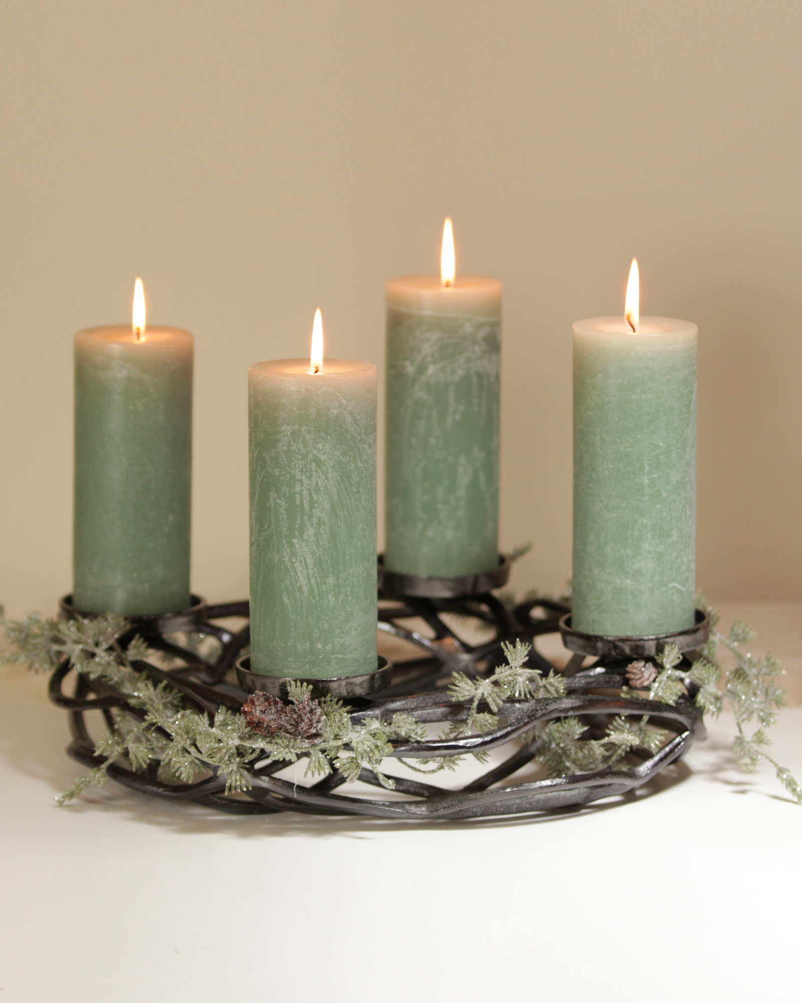 Adventskranz in Treibholz-Optik in Anthrazit mit vier salbeigrünen Kerzen.