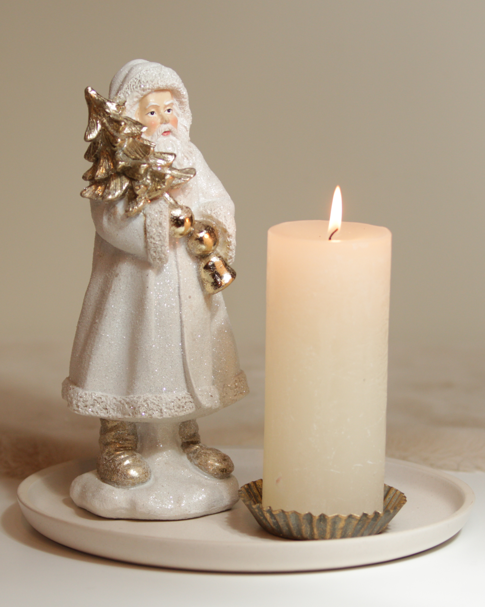 Dekoset mit Nikolausfigur und Kerze auf beigen Keramikteller.