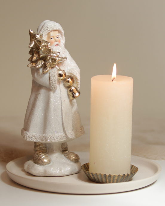 Dekoset mit Nikolausfigur und Kerze auf beigen Keramikteller.