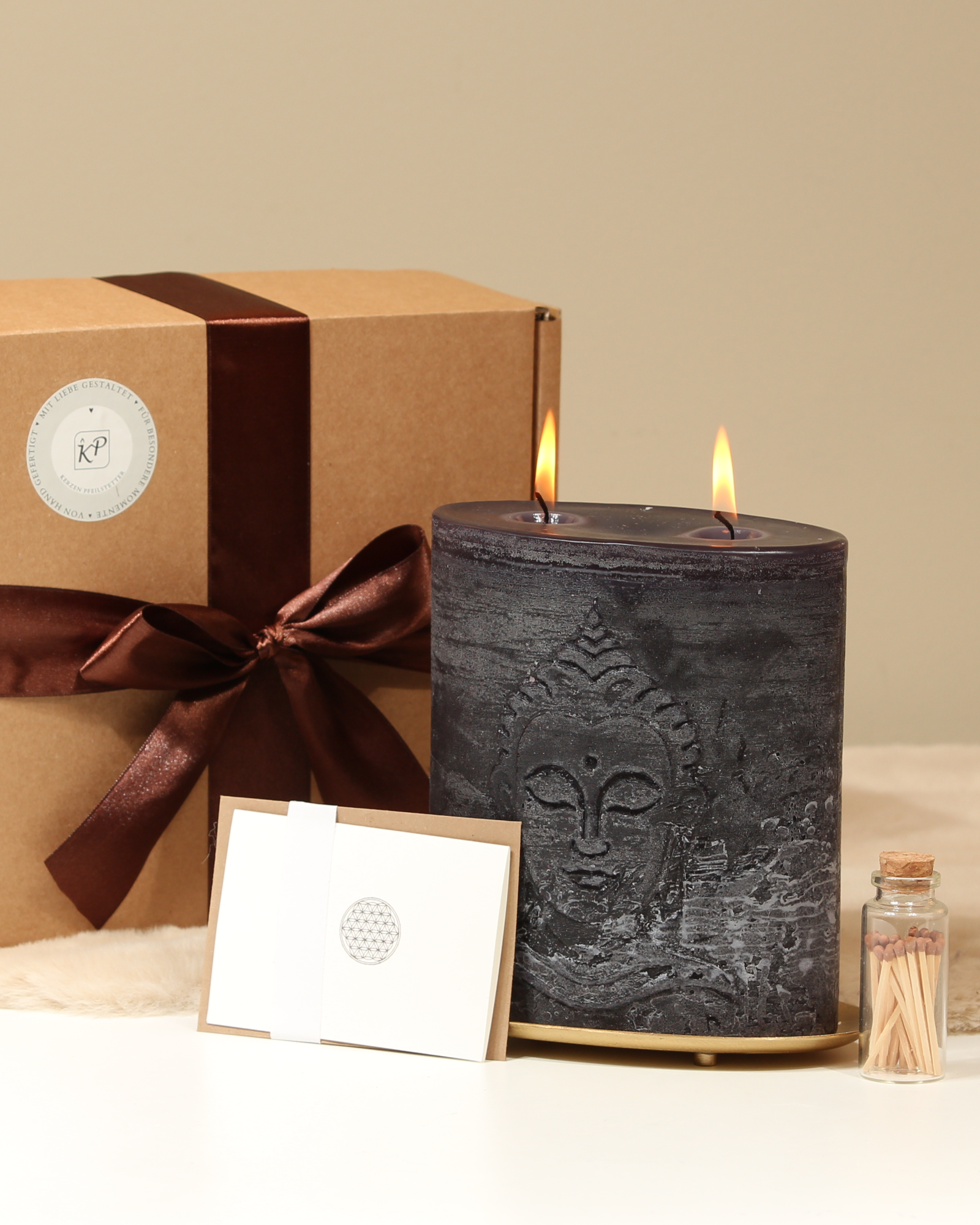 Geschenkbox Buddha Schwarz mit Kerze und Accessoires davor arrangiert