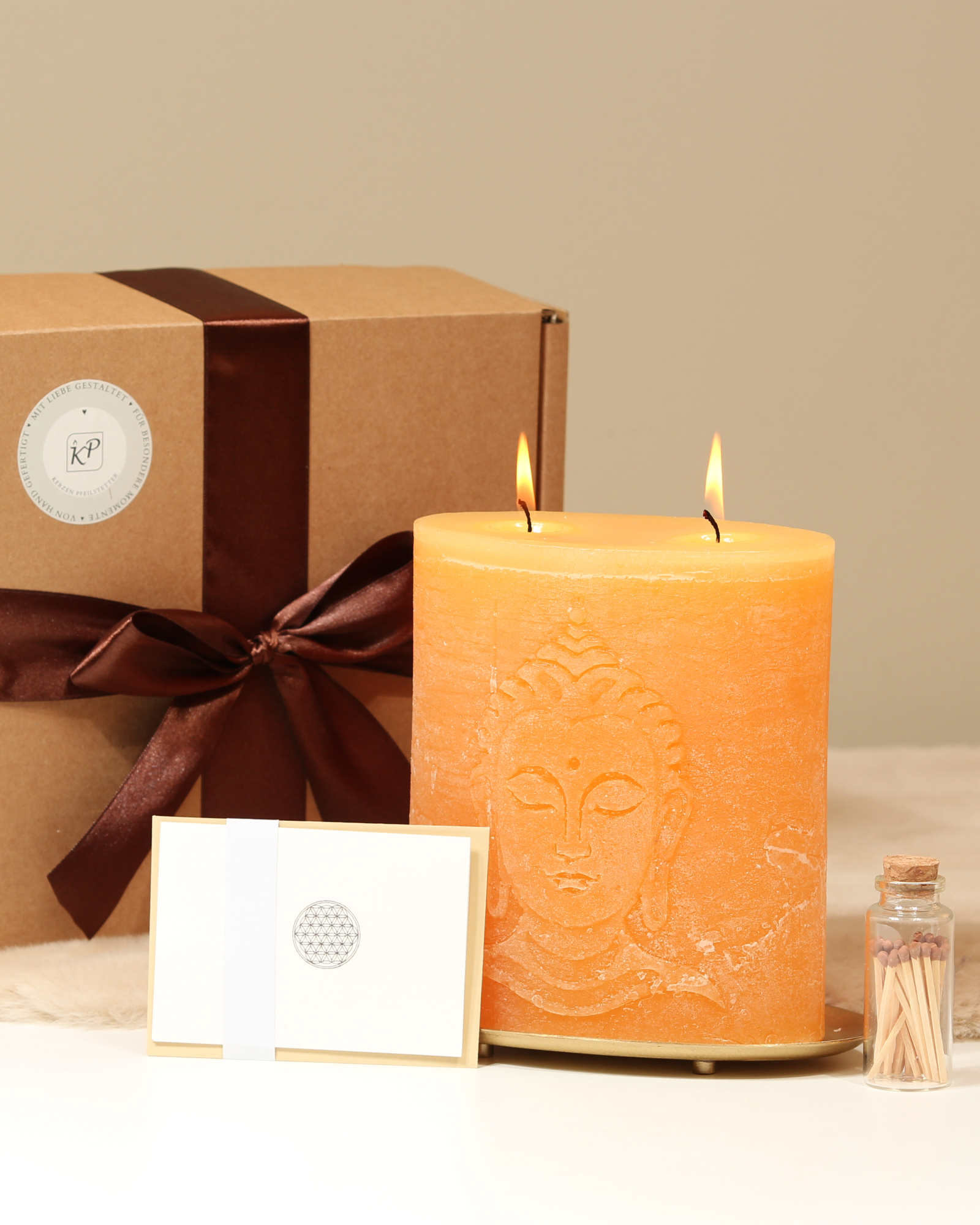 Geschenkbox Buddha Sonnengelb mit Kerze und Zubehör davor präsentiert