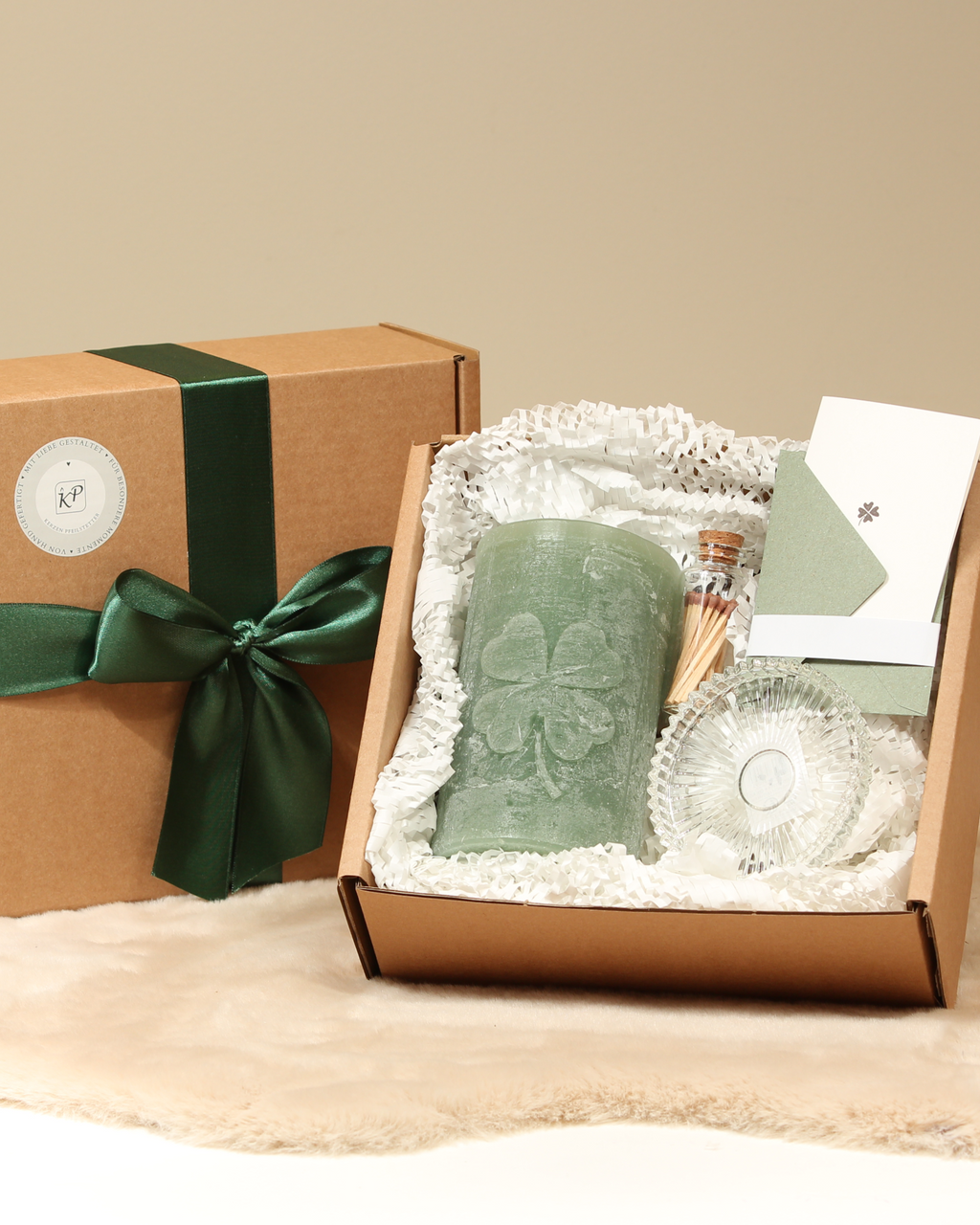 Geschenkbox mit handgegossener Kleeblatt-Kerze in Salbeigrün, Glasteller, Streichhölzer und Karte