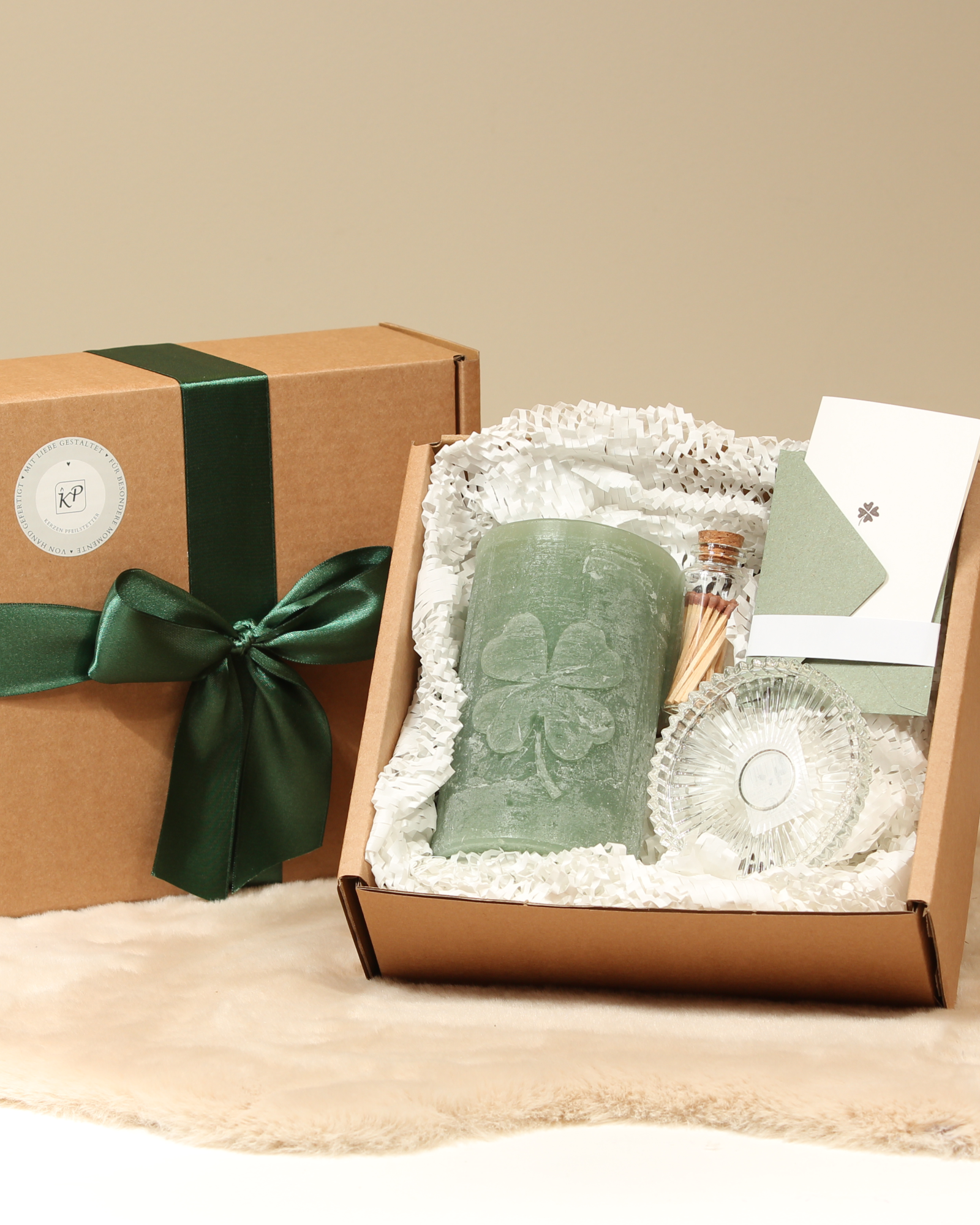 Geschenkbox mit handgegossener Kleeblatt-Kerze in Salbeigrün, Glasteller, Streichhölzer und Karte