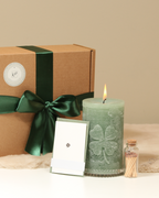 Geschenkbox Kleeblatt Salbeigrün mit Kerze und Zubehör davor präsentiert