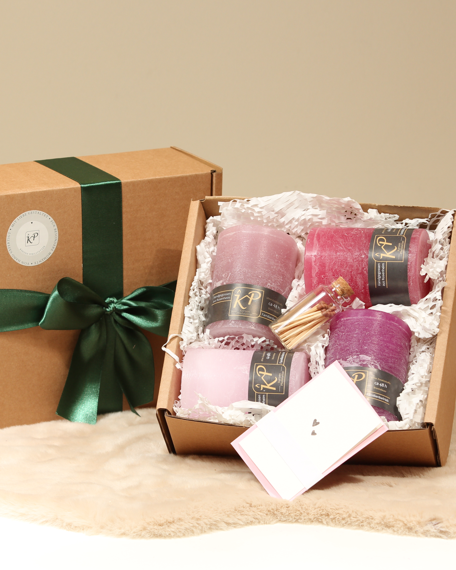 Geschenkbox mit vier Tischkerzen in Pastellrosa, Altrosa, Magenta und Himbeerrosa, Streichhölzer und Karte