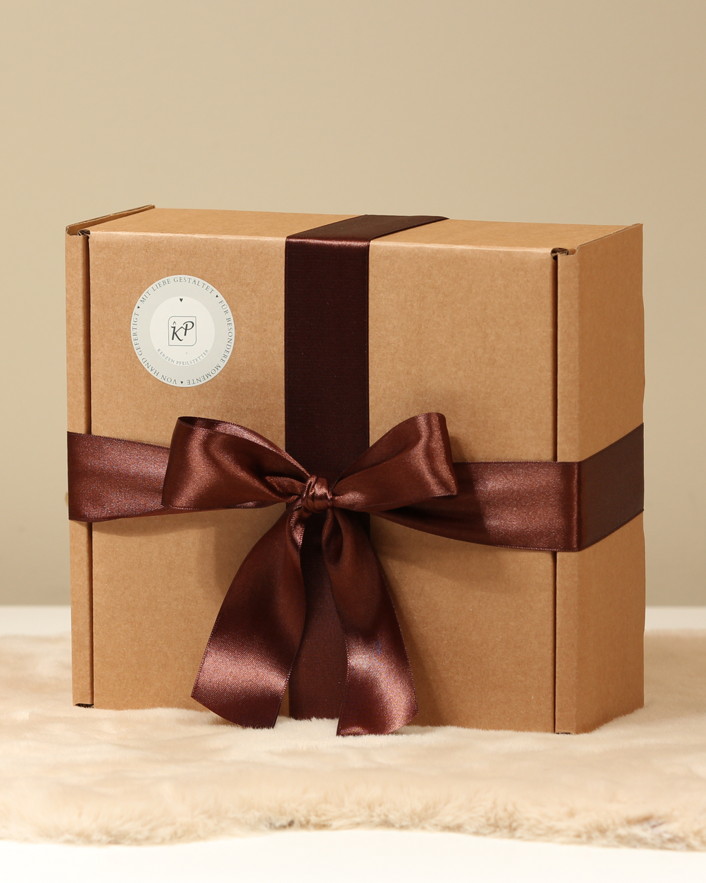 Nachhaltig verpackte Geschenkbox mit braunem Satinband – Kerzen Pfeilstetter