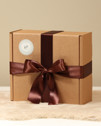 Nachhaltig verpackte Geschenkbox mit braunem Satinband – Kerzen Pfeilstetter
