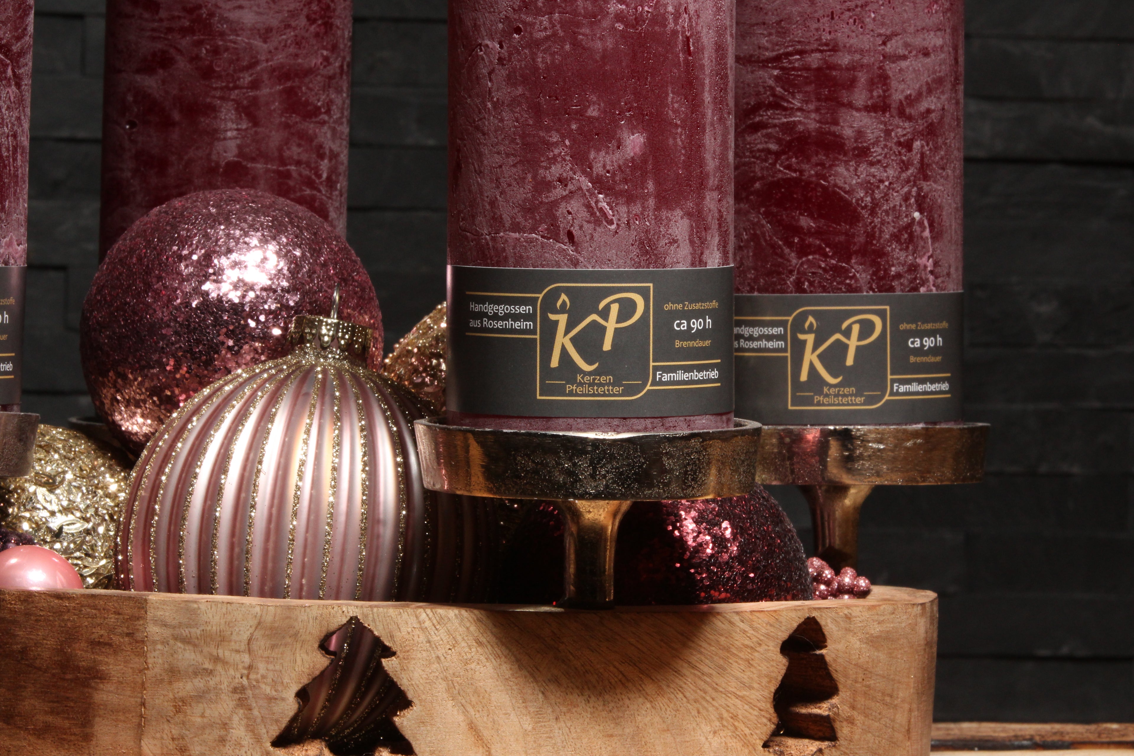 Handgegossene Blütenkerzen in Burgundrot, dekoriert mit Weihnachtskugeln und goldenen Akzenten – handgefertigt in der Kerzenmanufaktur Pfeilstetter in Rosenheim.