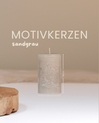 Kerze mit Buddha-Motiv in sandgrau mit Angaben zu Höhe und Durchmesser.