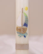Nahaufnahme des maritimen Motivs mit Segelschiff und goldener Sonne – handverziert auf Kommunionskerze von Wiedemann.