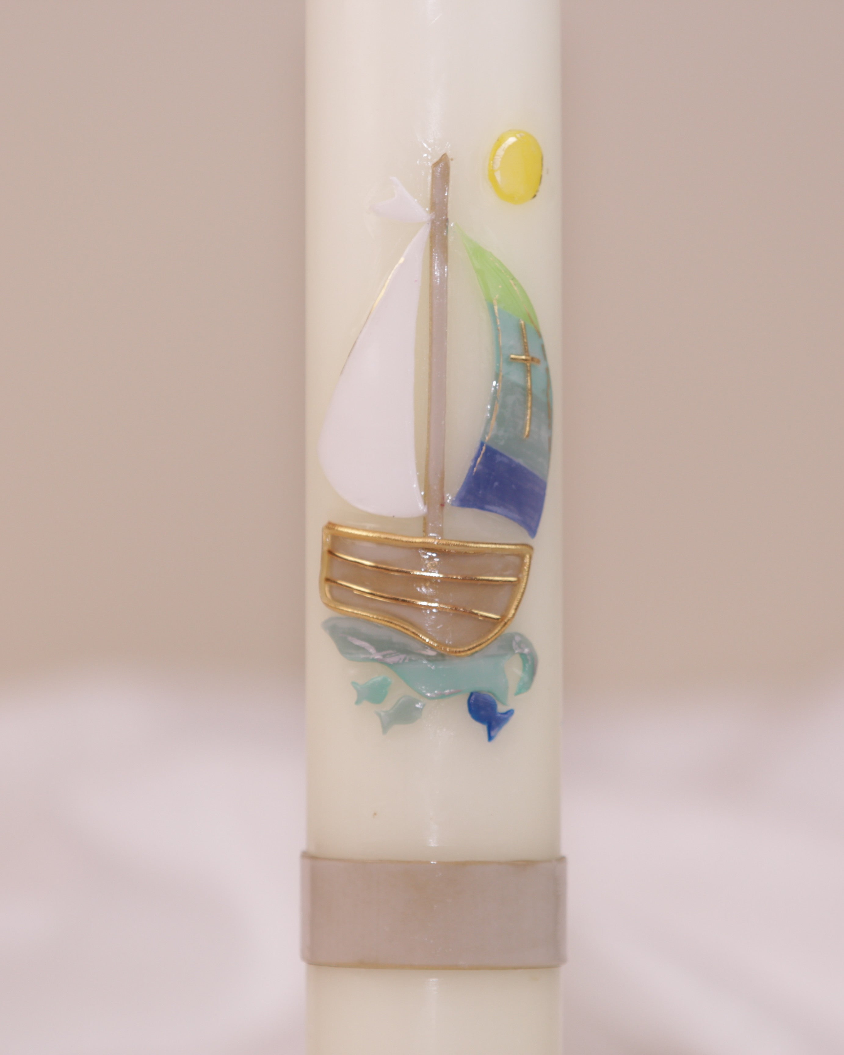 Nahaufnahme des maritimen Motivs mit Segelschiff und goldener Sonne – handverziert auf Kommunionskerze von Wiedemann.