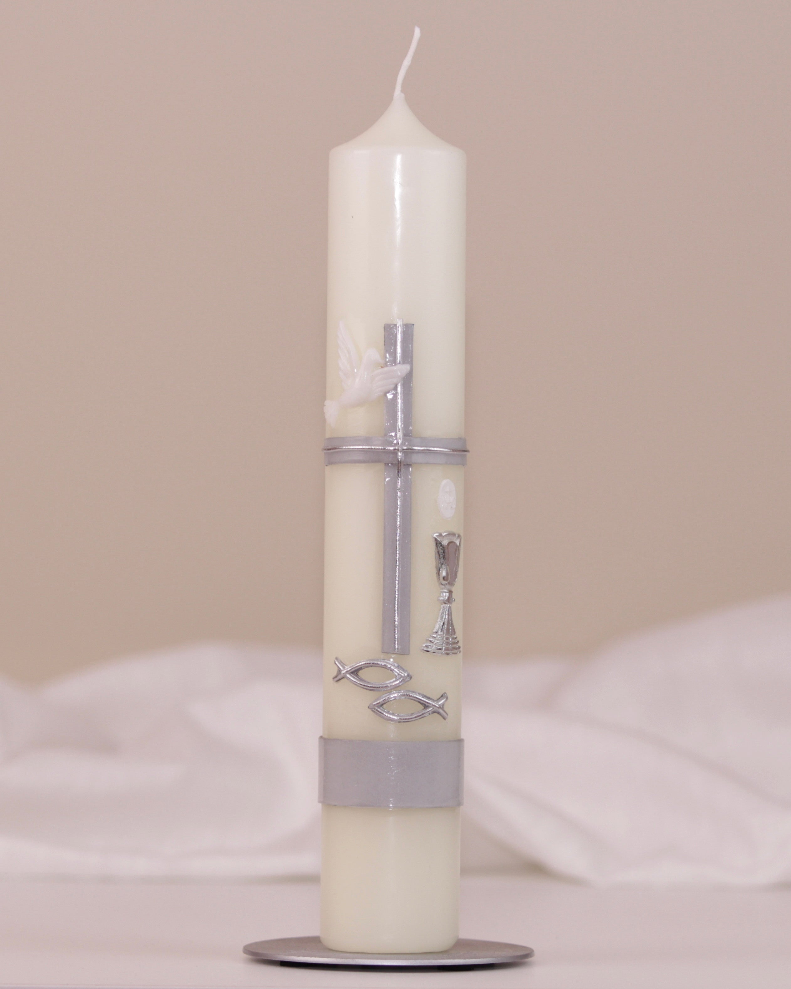 Kommunionskerze mit silbernem Kreuz, Taube, Kelch und Fischsymbol auf weißem Hintergrund – traditionell verziert von Wiedemann.