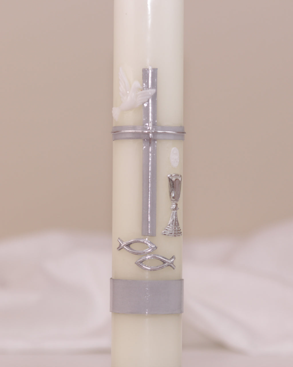 Detailansicht der silbernen Verzierung mit Kreuz, Taube, Kelch und Fischsymbol – handverziert auf Kommunionskerze von Wiedemann.