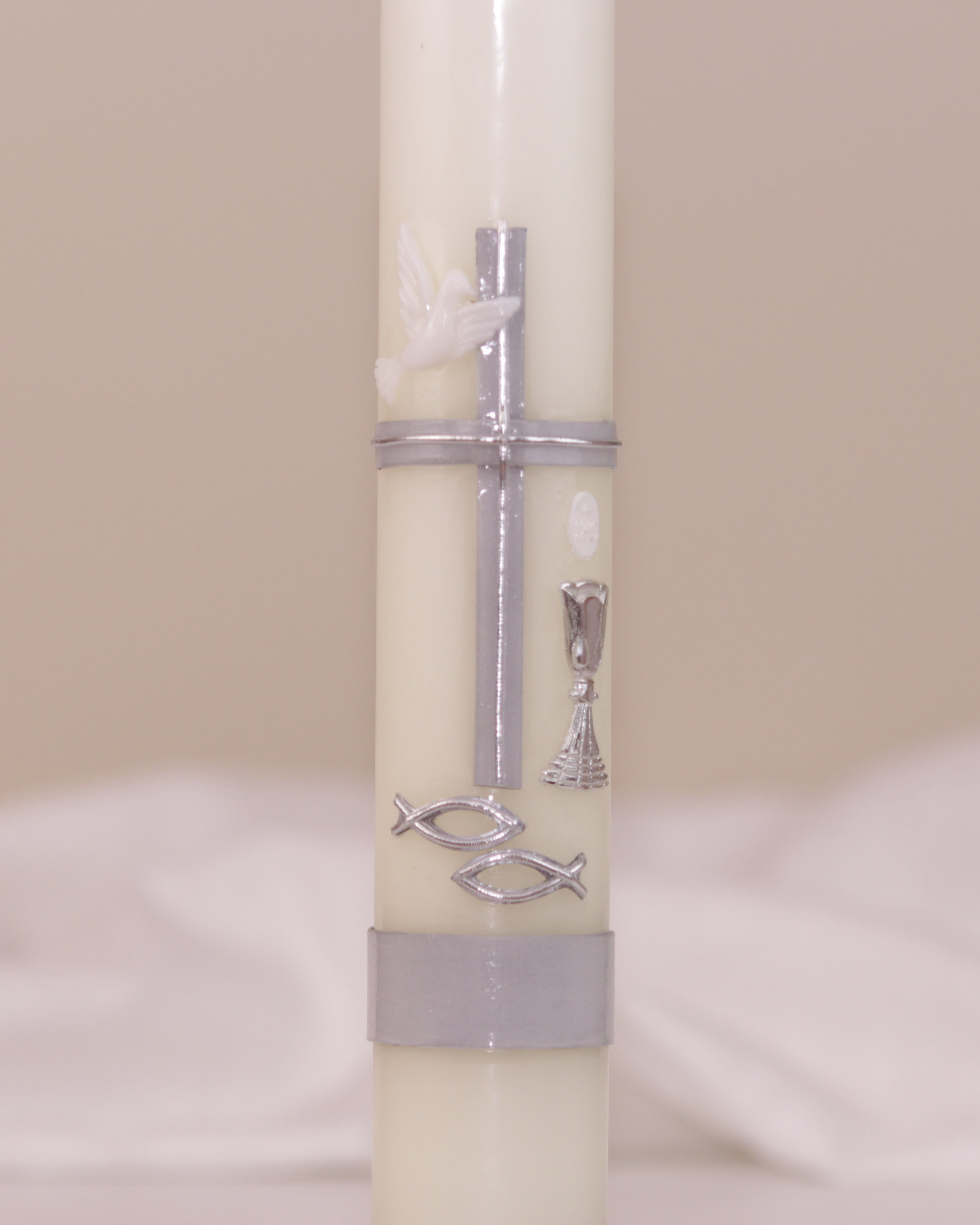 Detailansicht der silbernen Verzierung mit Kreuz, Taube, Kelch und Fischsymbol – handverziert auf Kommunionskerze von Wiedemann.