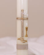Detailansicht der goldfarbenen Verzierung mit Kreuz, Taube, Kelch und zwei Fischsymbolen – traditionell verziert auf Kommunionskerze von Wiedemann.