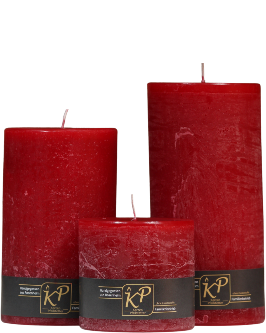Drei Stumpenkerzen in weihnachtsrot nebeneinander – in den Größen Klein, Mittel und Groß.