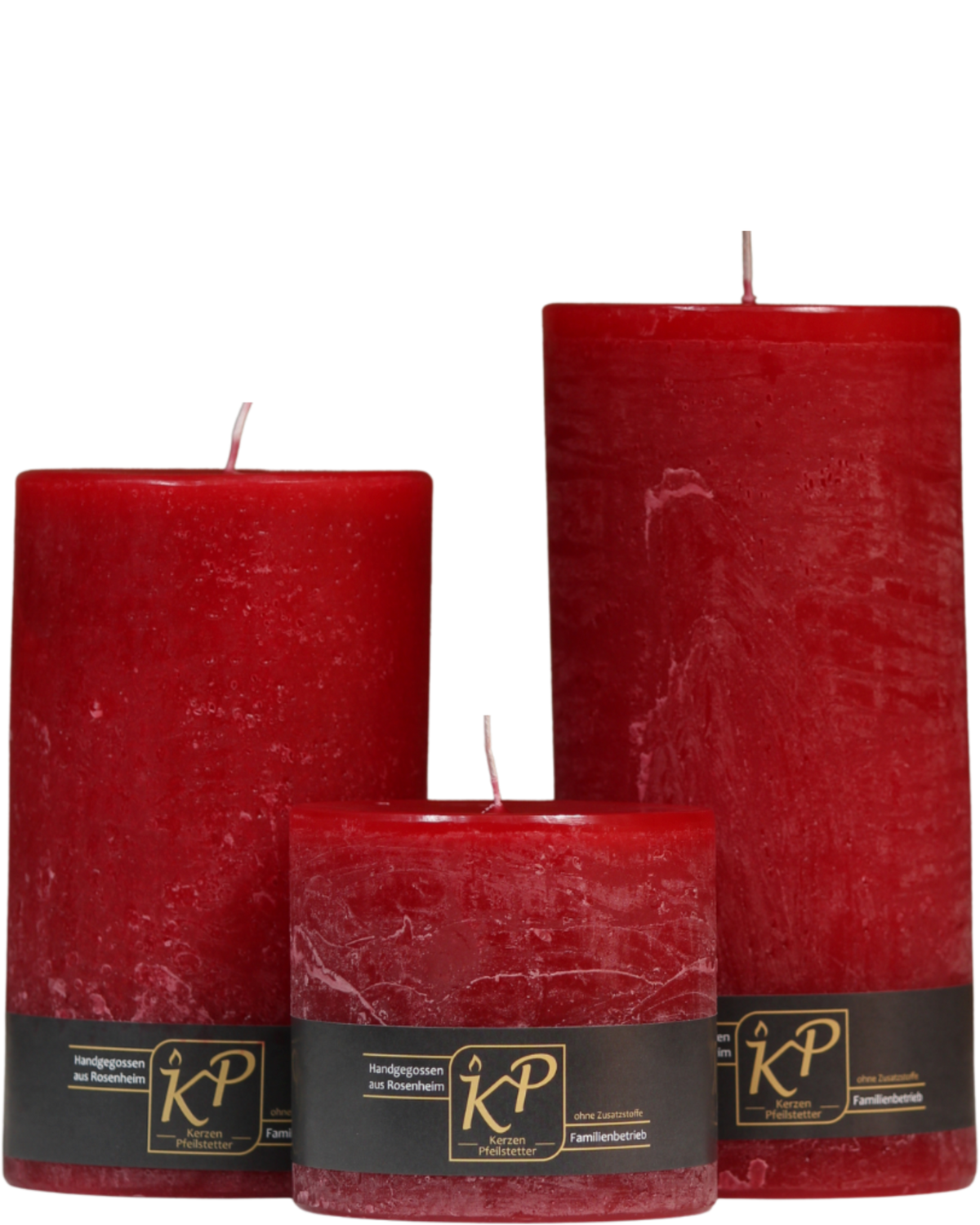 Drei Stumpenkerzen in weihnachtsrot nebeneinander – in den Größen Klein, Mittel und Groß.