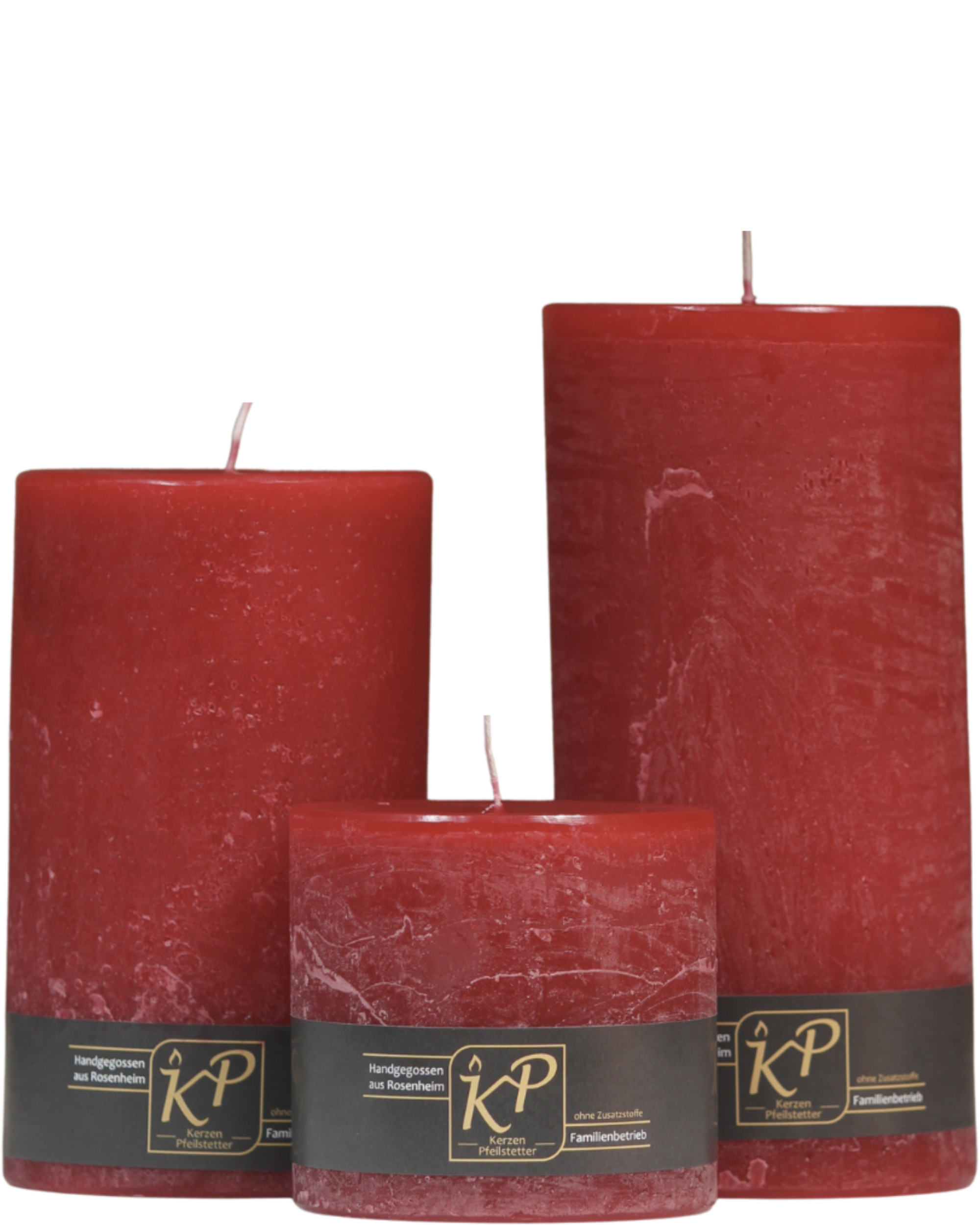 Drei Stumpenkerzen in weihnachtsrot nebeneinander – in den Größen Klein, Mittel und Groß.