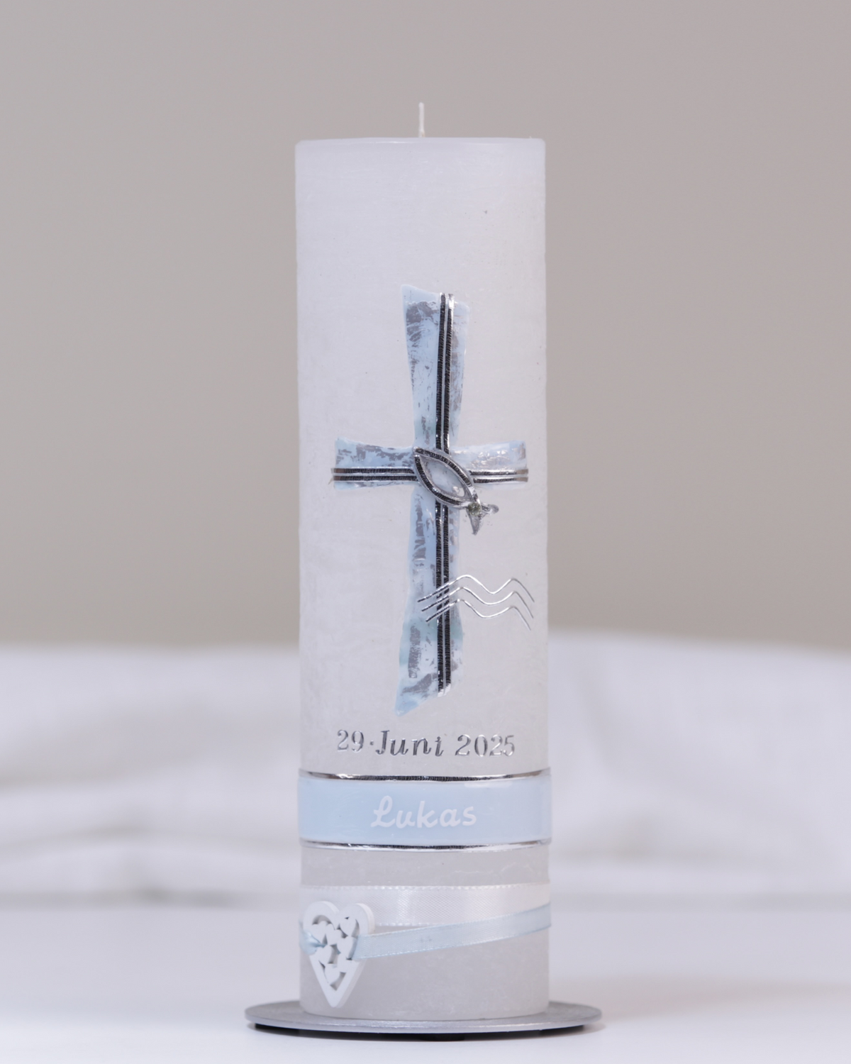 Weiße Taufkerze mit silber-blauer Verzierung aus Kreuz, Fisch, Wasserzeichen und Verzierband.