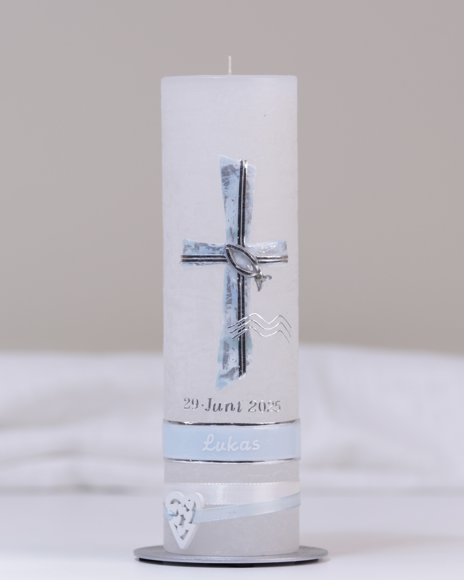 Weiße Taufkerze mit silber-blauer Verzierung aus Kreuz, Fisch, Wasserzeichen und Verzierband.