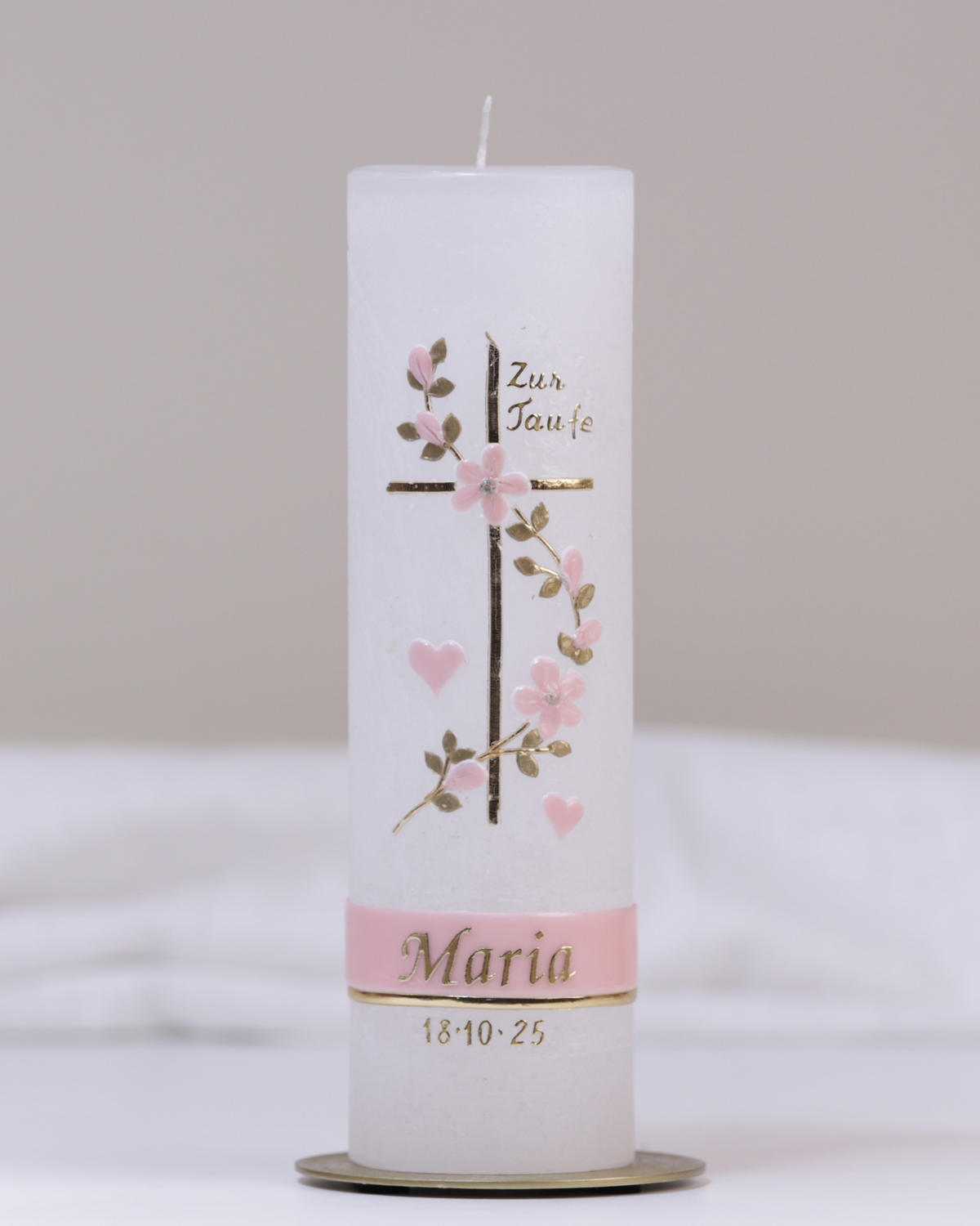 Weiße Taufkerze mit rosa-goldener Verzierung aus Kreuz, Herz, Blumenranke und „Meine Taufe“-Schriftzug.