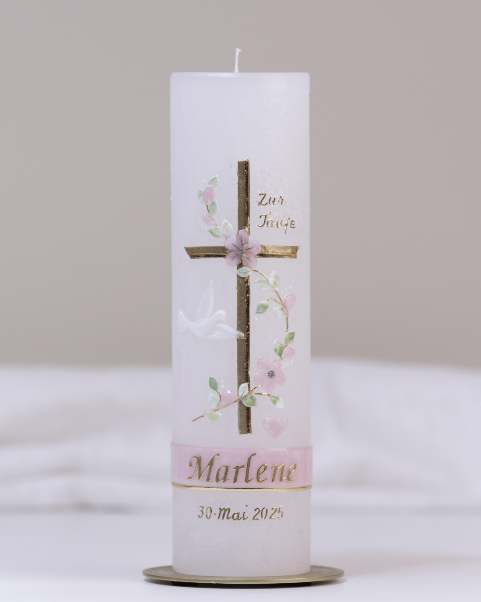 Weiße Taufkerze mit rosa-goldener Verzierung aus Kreuz, Taube, Blumenranke und „Meine Taufe“-Schriftzug.