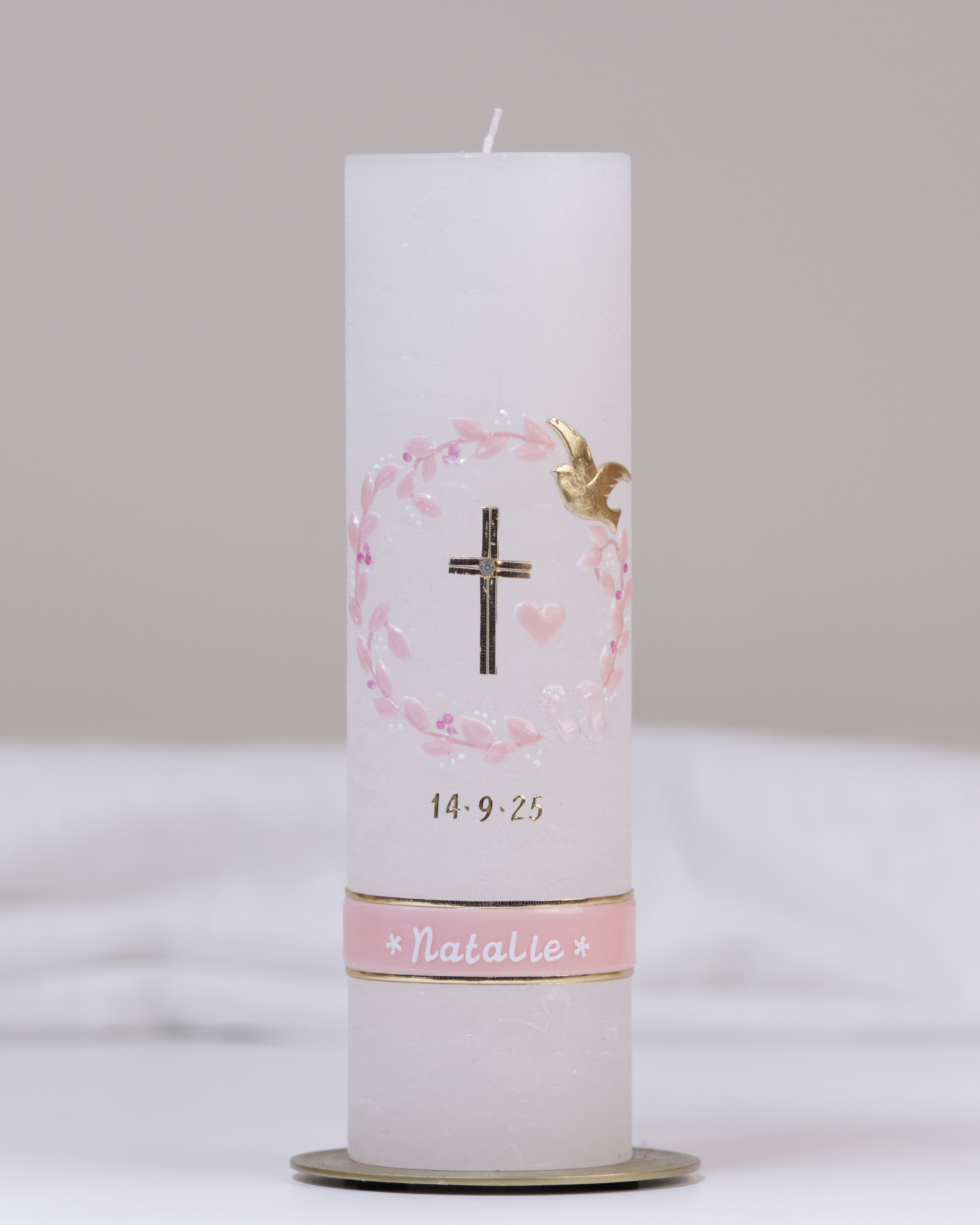 Weiße Taufkerze mit gold-rosa Verzierung aus Kreuz, Herz, Blumenranke und Schmetterlingen.