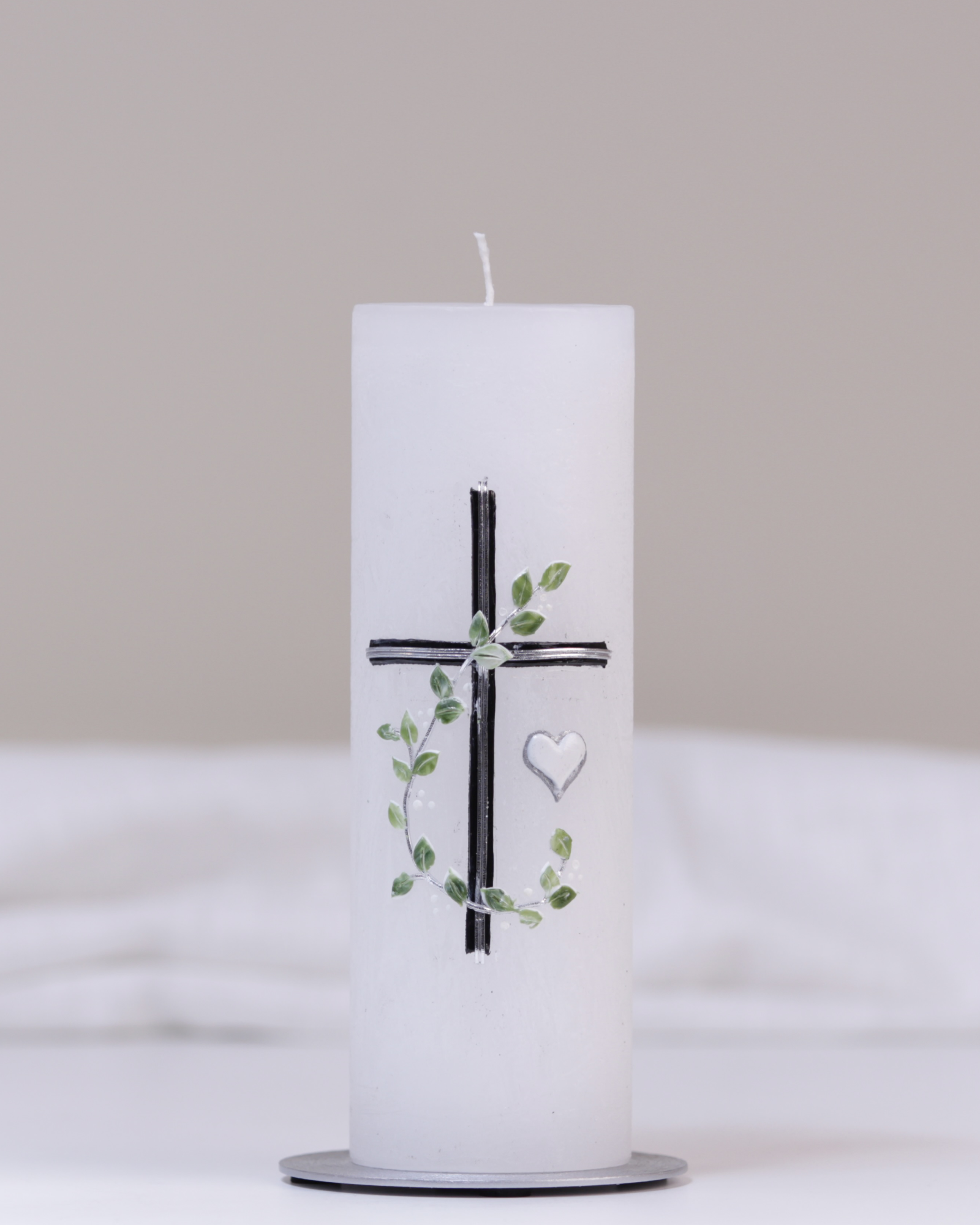 Weiße Trauerkerze mit silbernem Kreuz, Herz und grüner Blätterranke – handgefertigt und geeist für eine stilvolle Erinnerung.