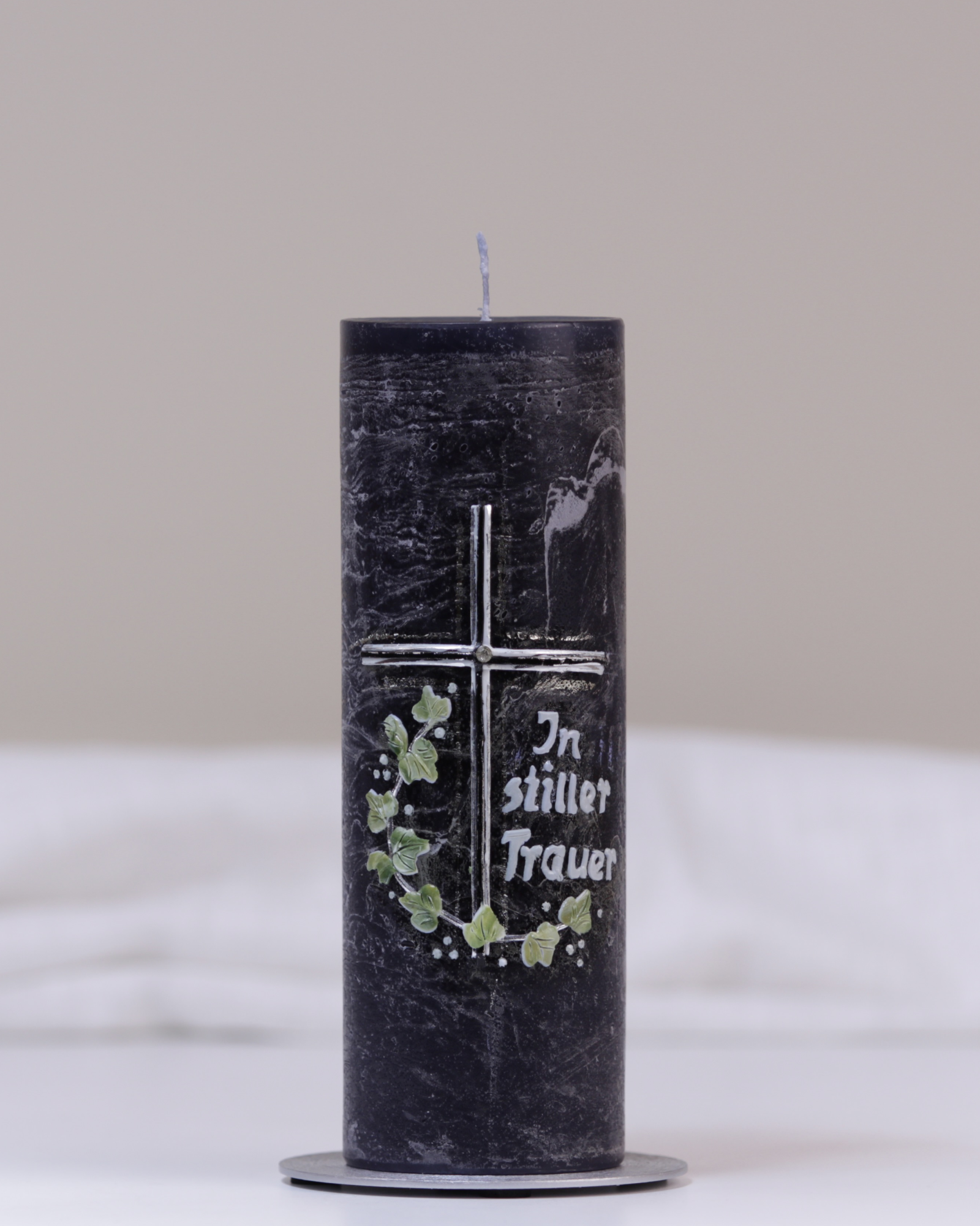 Schwarze Trauerkerze mit silbernem Kreuz, Blätterranke und Schriftzug „In stiller Trauer“ – liebevoll von Hand gegossen.
