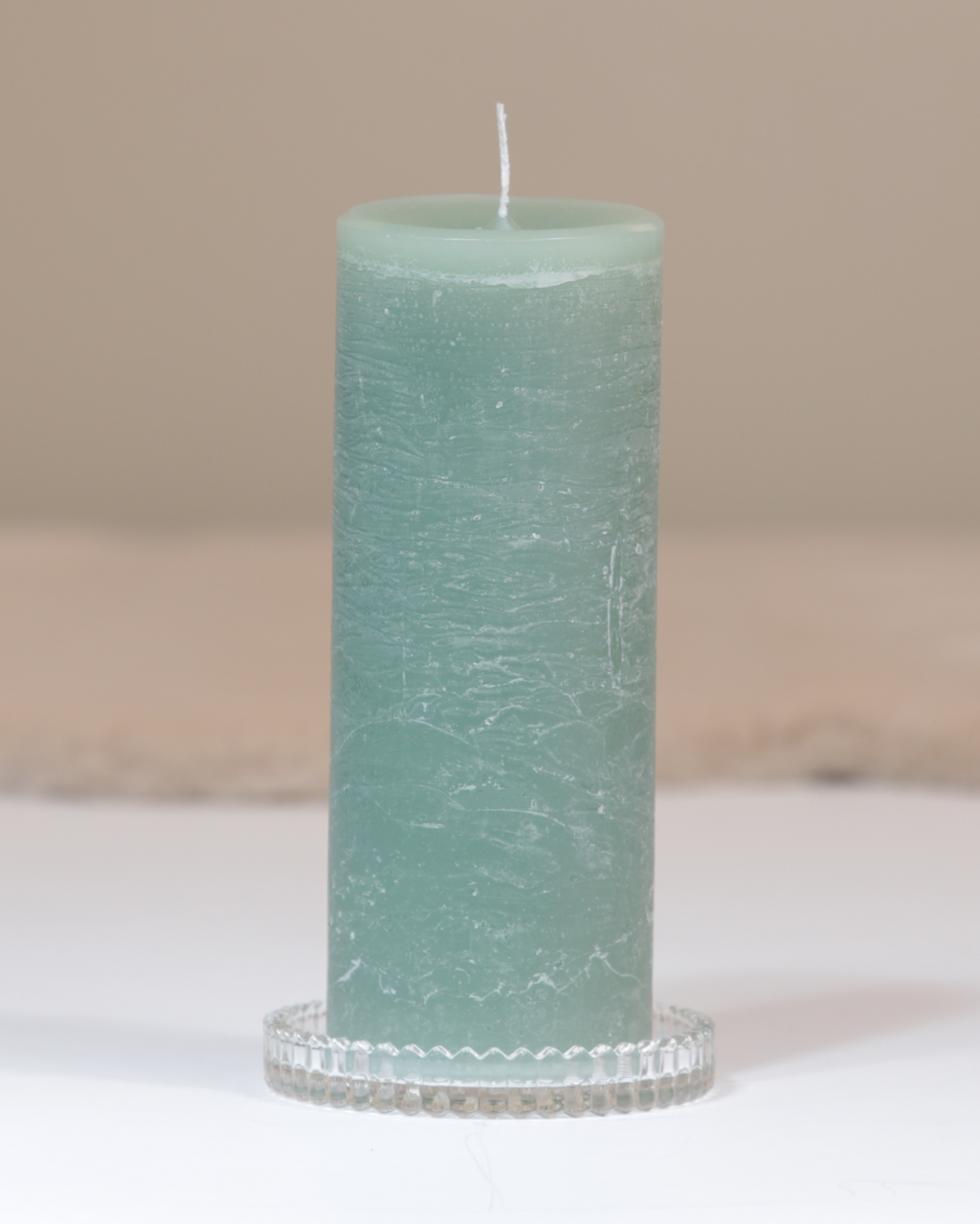 Kerzenteller aus klarem Glas mit facettierter Struktur mit Kerze.