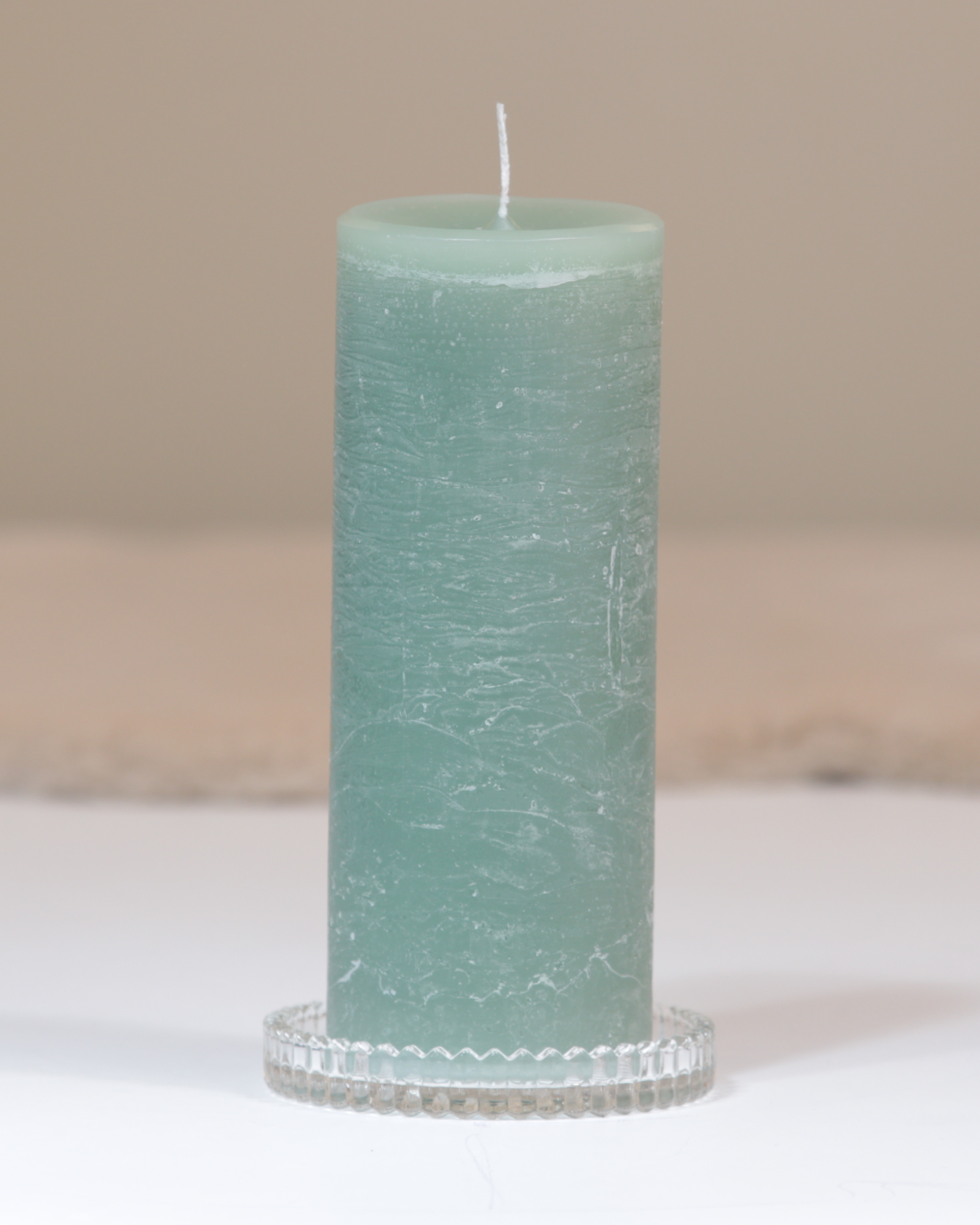 Kerzenteller aus klarem Glas mit facettierter Struktur mit Kerze.