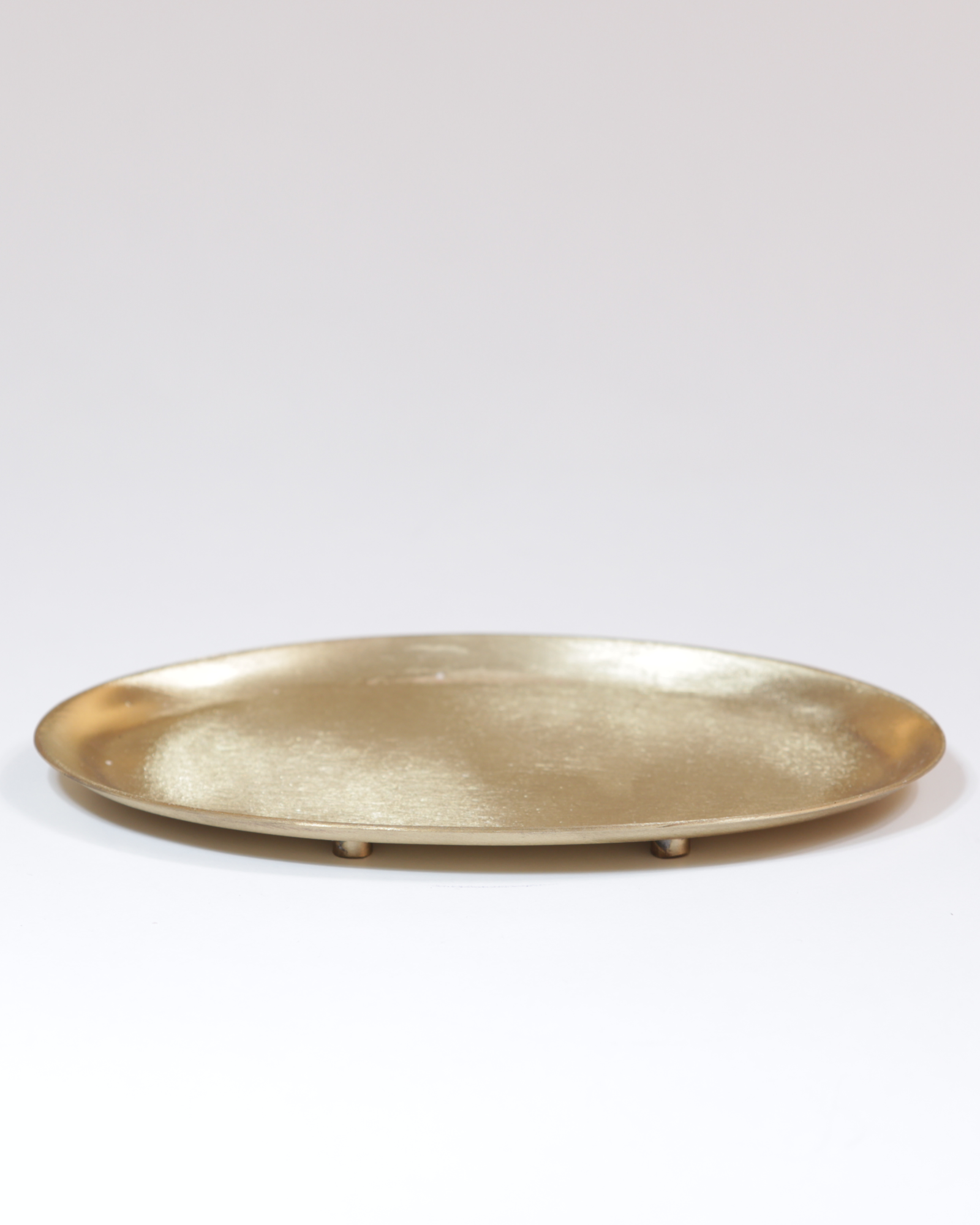 Kerzenteller aus Messing, oval, mattgoldfarben.